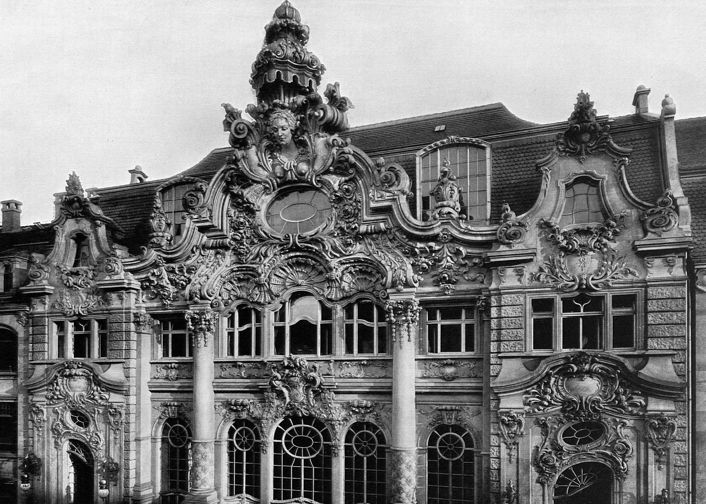 Ein Ausschnitt der Fassade: Stuck, Bögen und große Fenster.