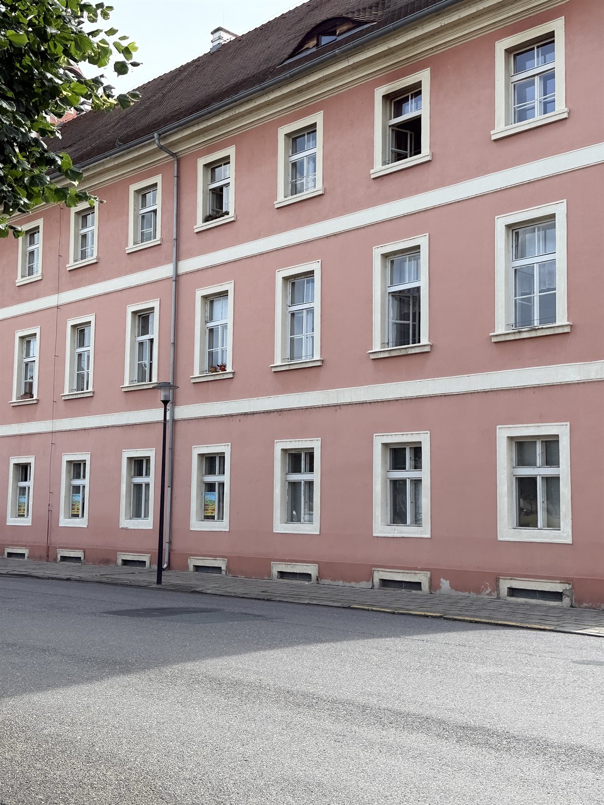 Rotes Gebäude mit auffällig tief im Boden sitzenden Kellerfenstern